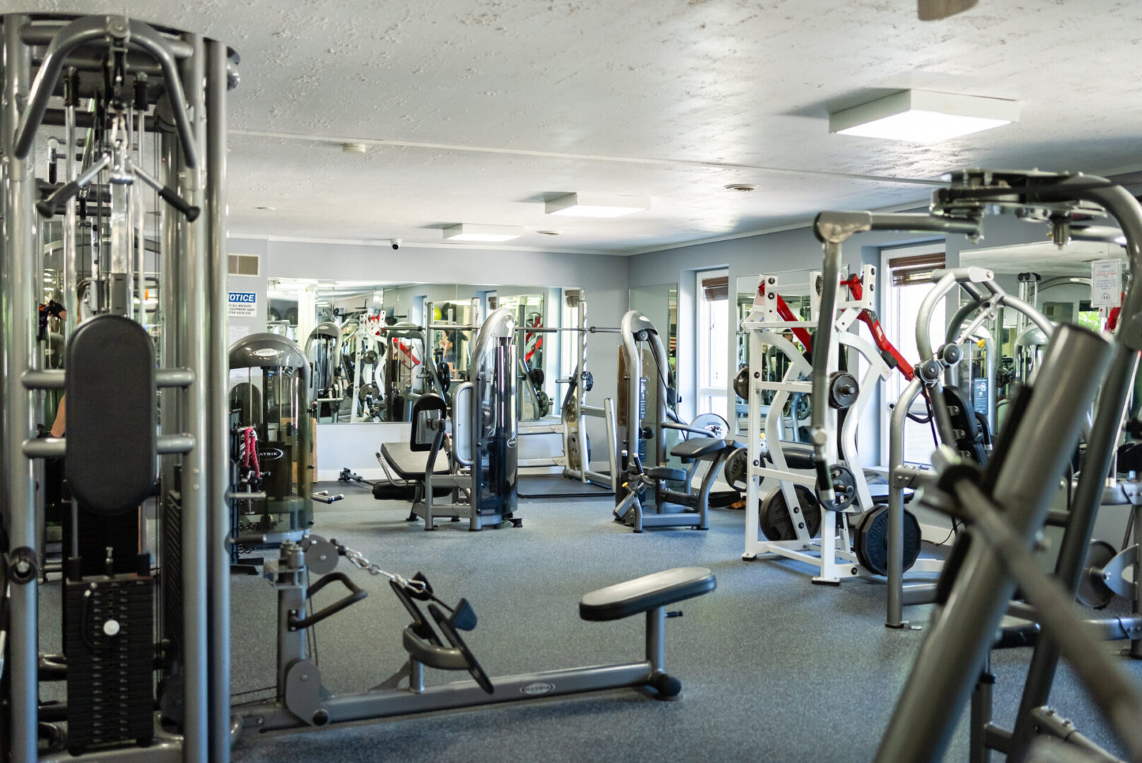 A gym with many different machines and people