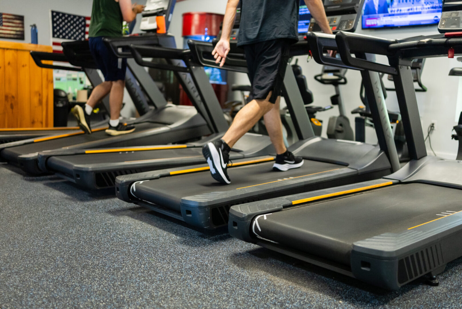 A group of people are walking on some treadmills.