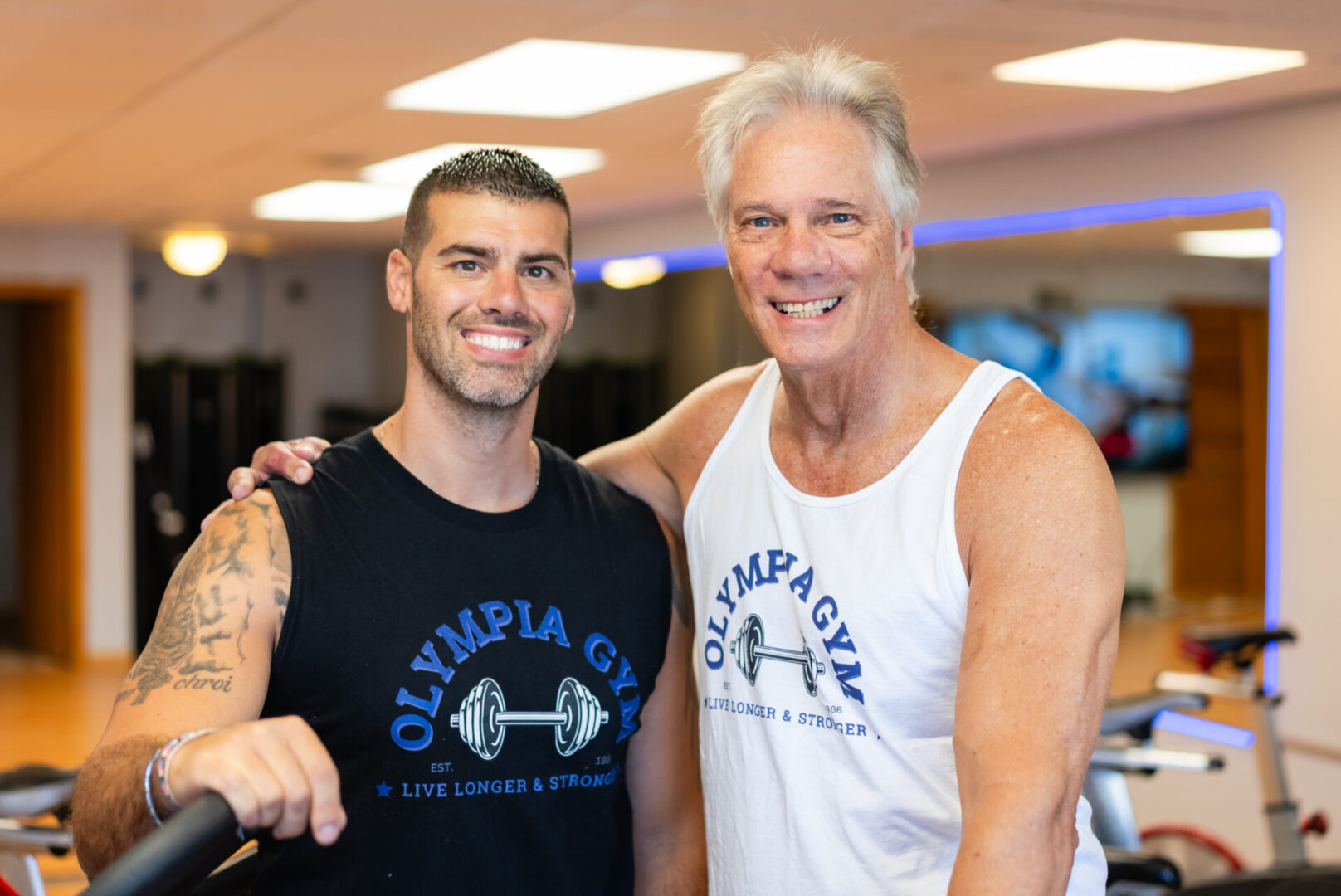 Two men posing for a picture in the gym.