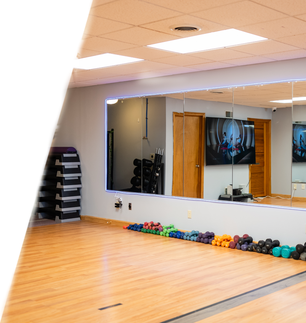 A gym with mirrors and wooden floors