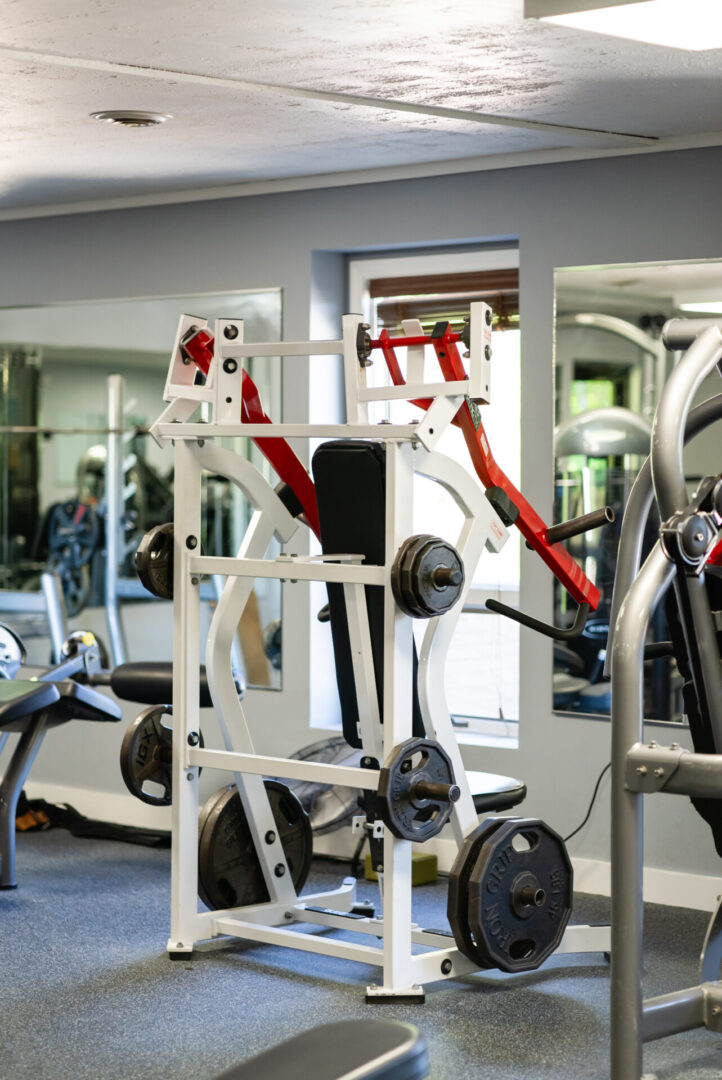 A gym with many machines and mirrors in it