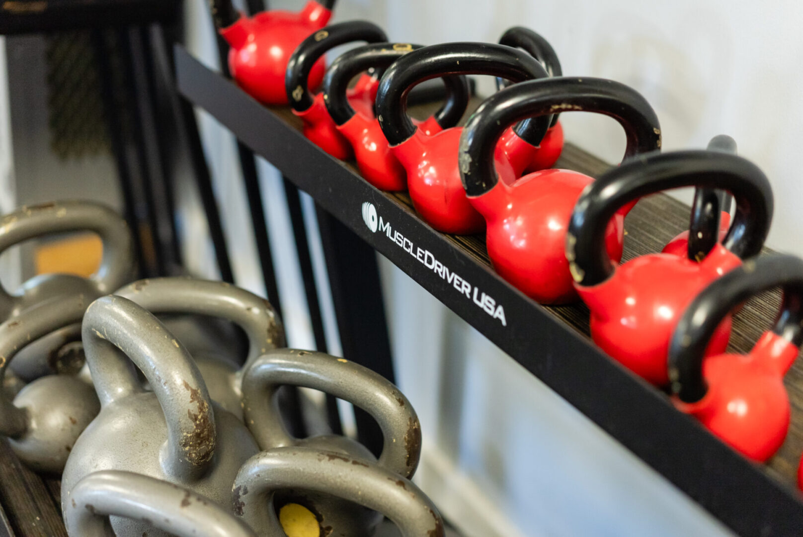 A rack of kettlebells and other gym equipment.