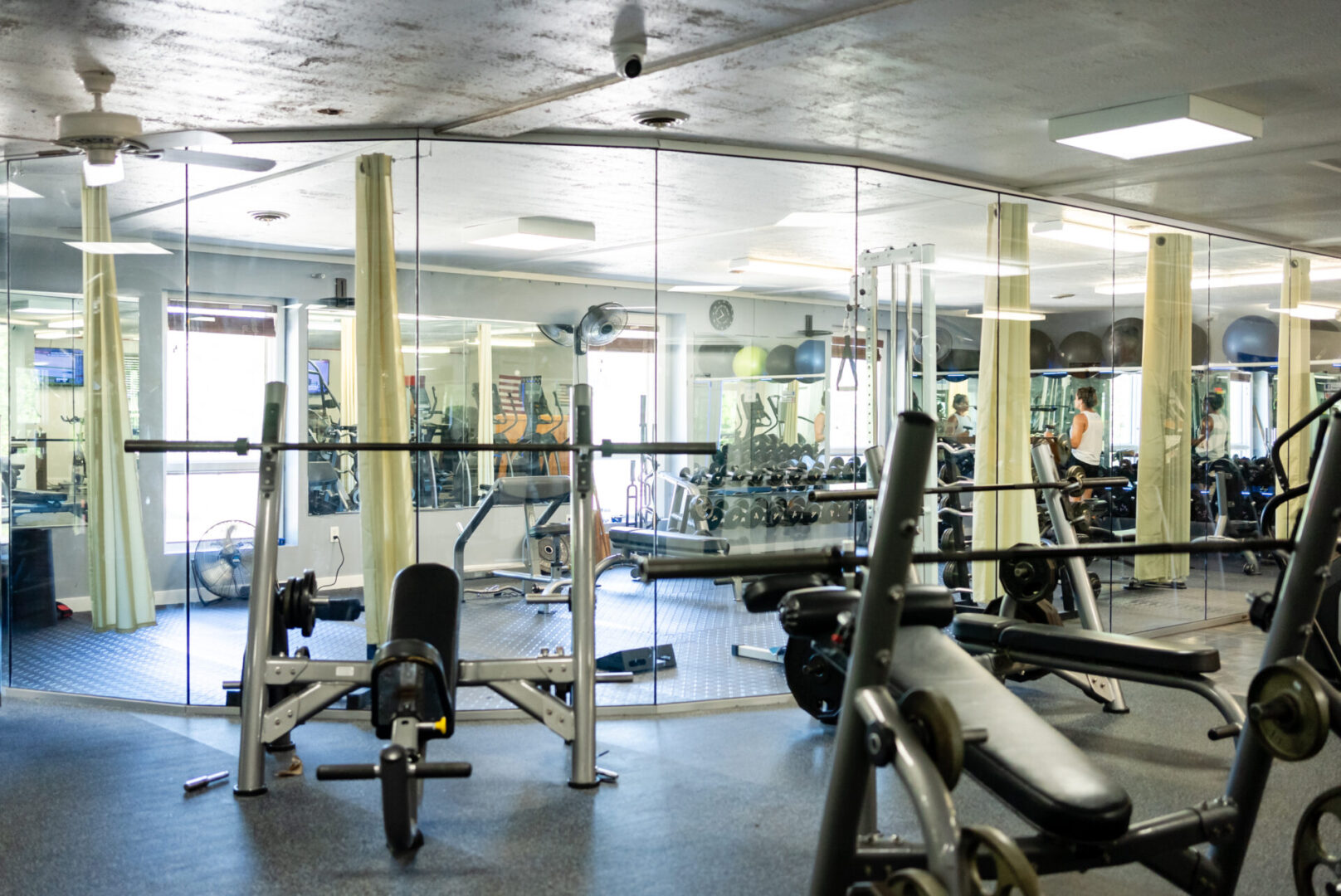 A gym with many machines and mirrors