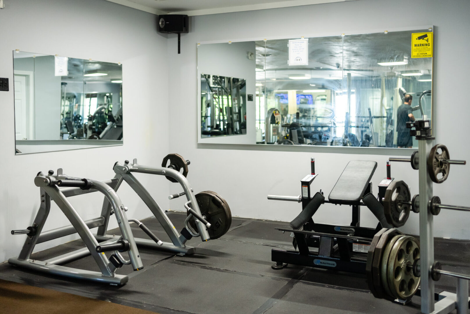 A gym with many different machines and mirrors