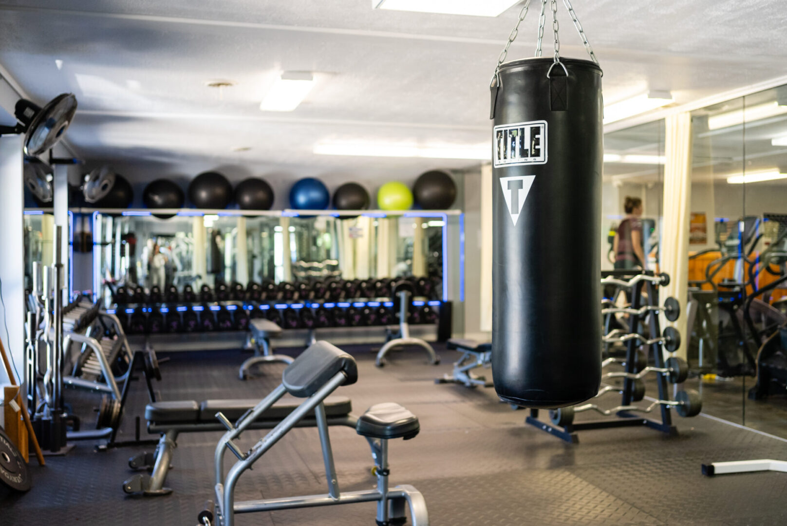 A gym with many different equipment and a punching bag.