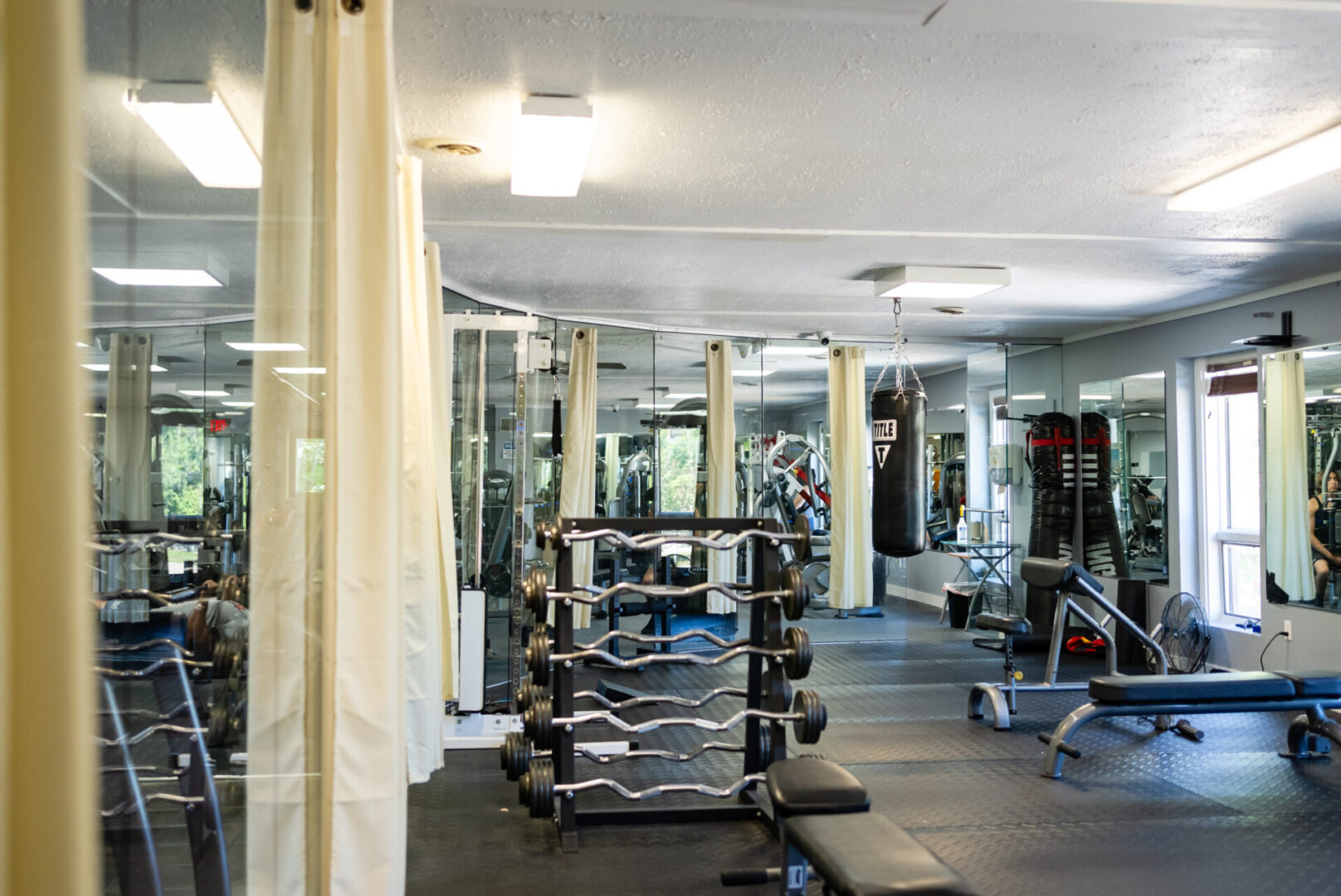 A gym with many machines and mirrors