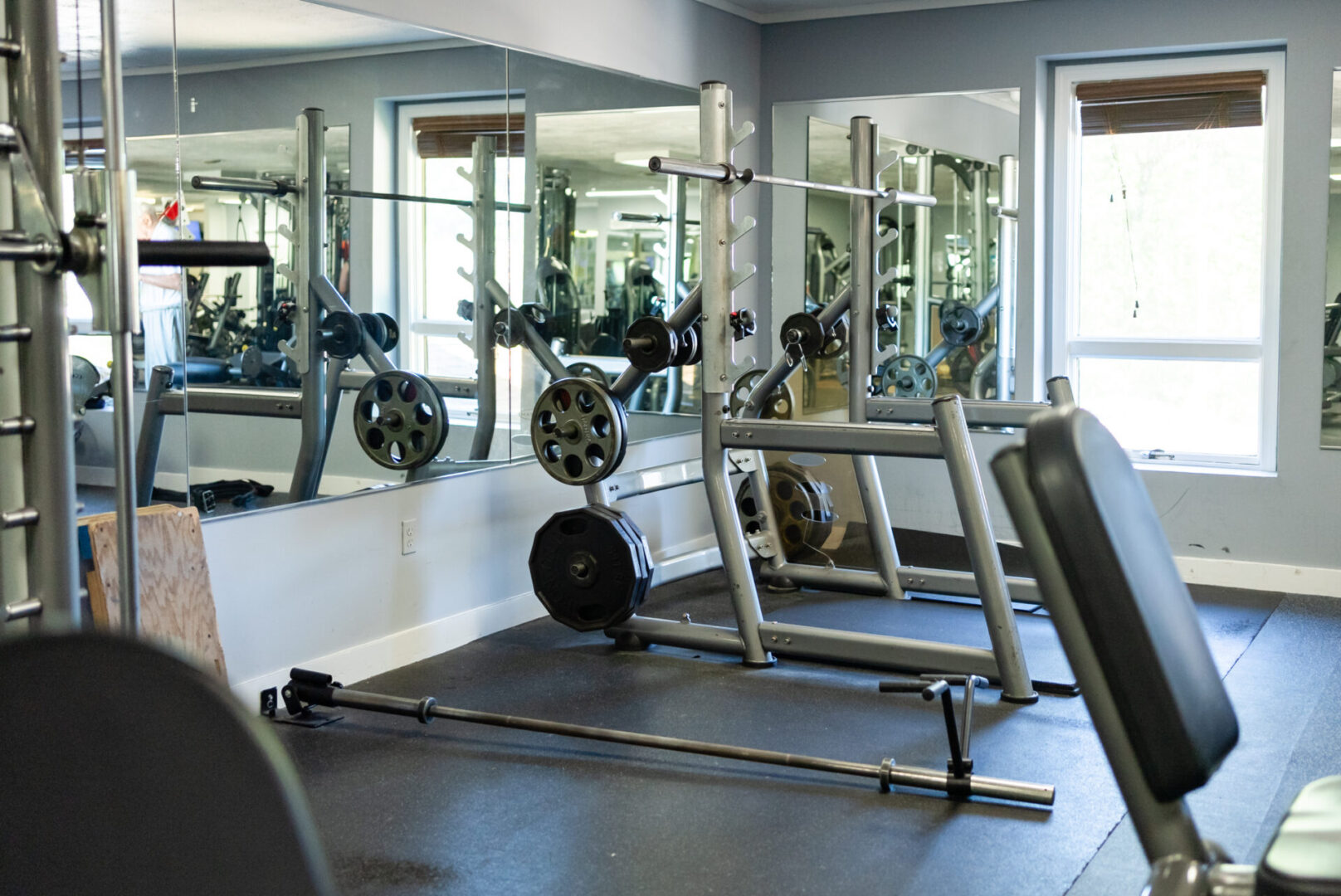 A gym with many mirrors and some machines